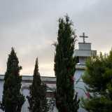 Tra le fronde riusciamo a scorgere il campanile sovrastato da una croce...